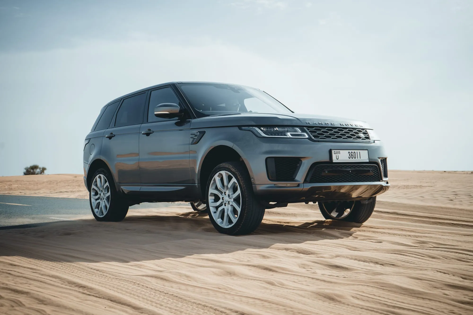 Silver luxury SUV parked on desert sand