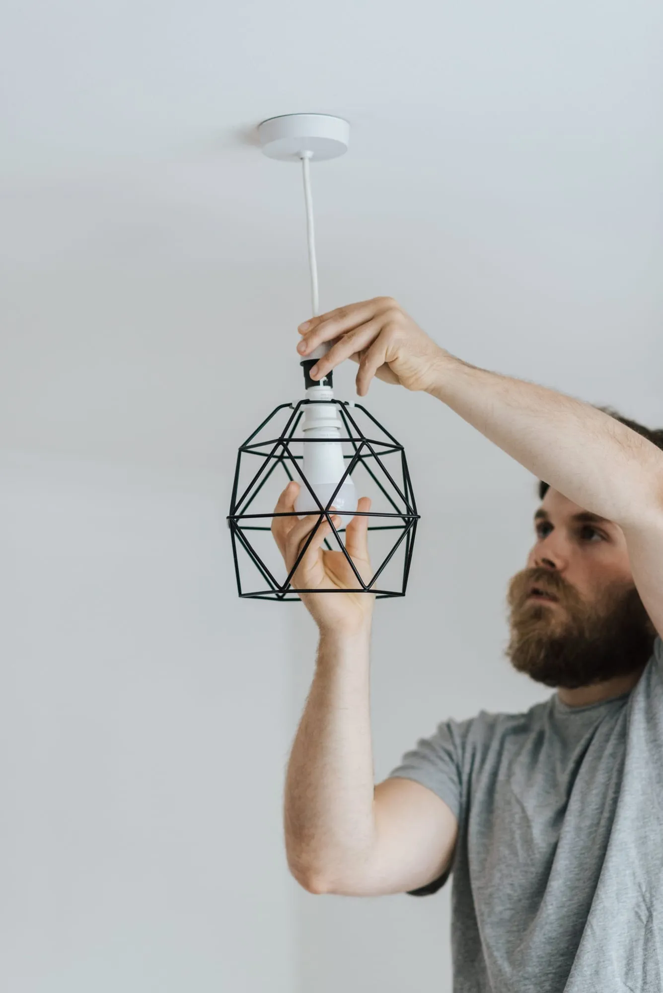 Electrician installing a geometric pendant light