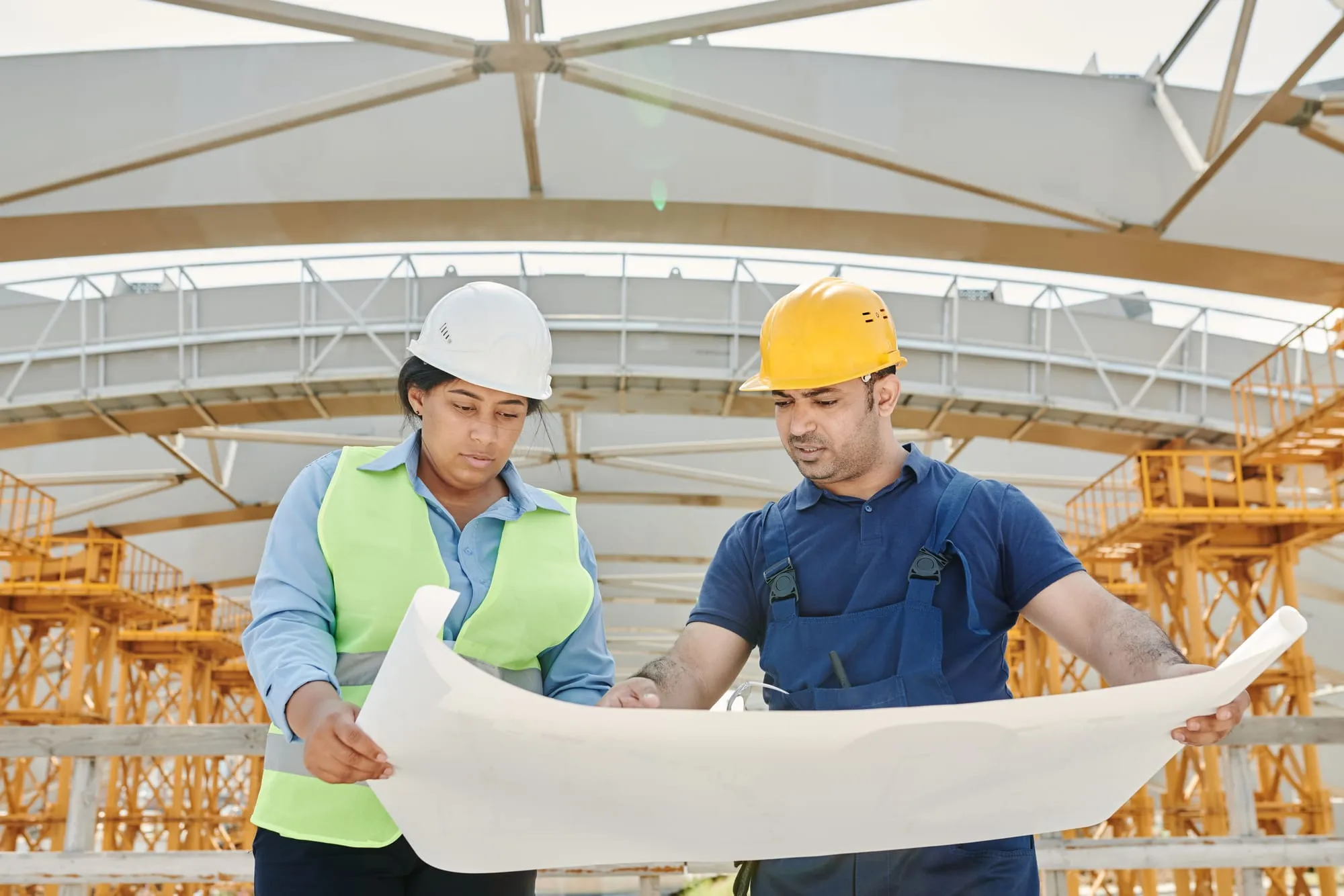 Two engineers reviewing drawings on site