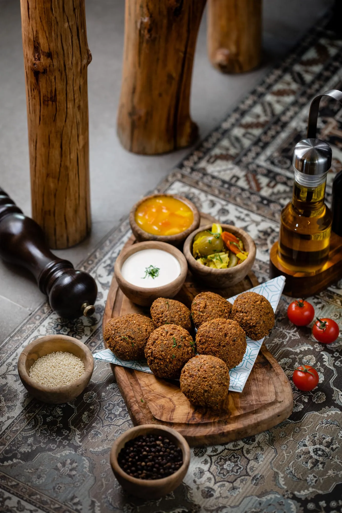 Falafel with dips and pickles on a wooden board