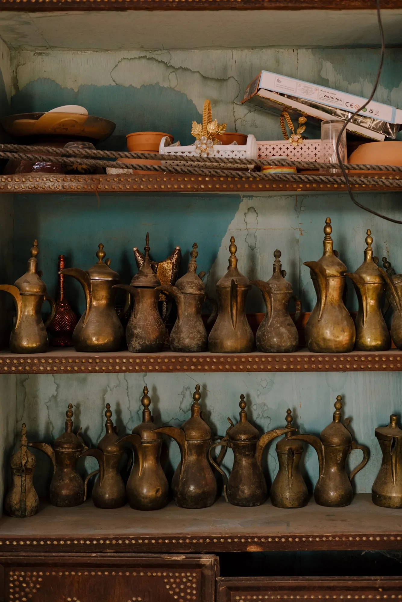 Row of traditional brass coffee pots on a shelf