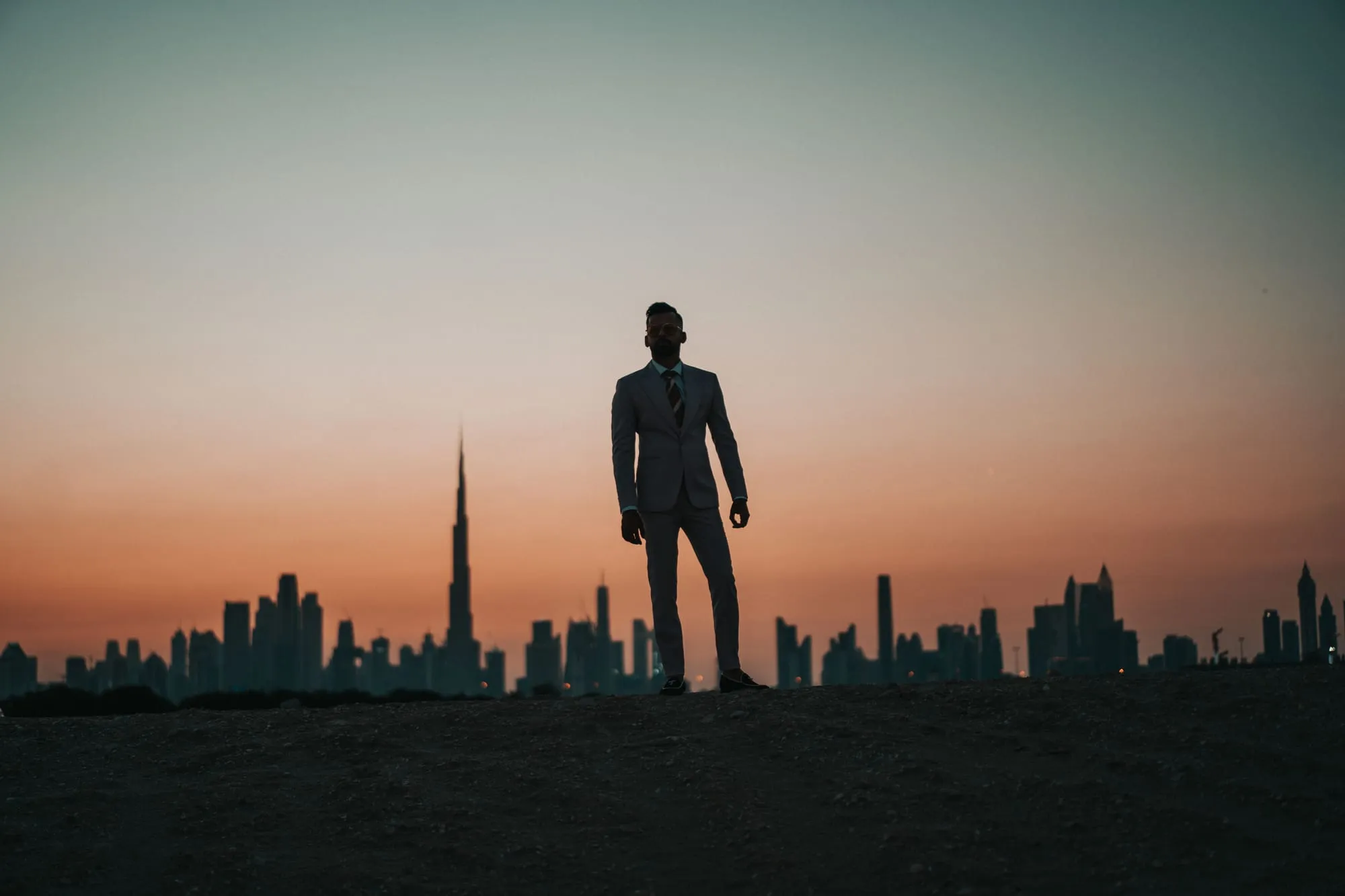 Silhouette of a man facing the Dubai skyline at sunset