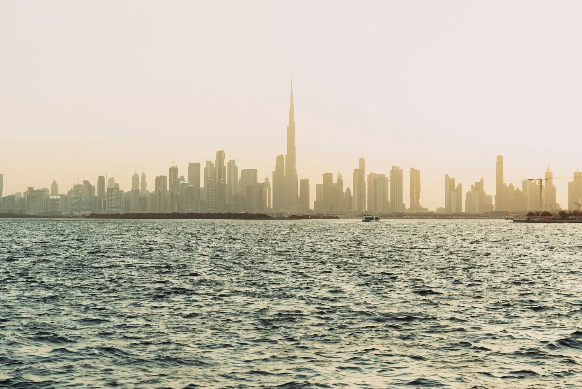 Dubai skyline seen across the sea in soft haze
